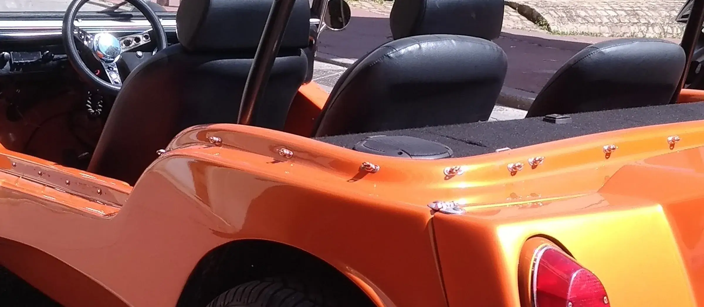 Buggy orange ouvert, sièges noirs, sans plaque visible