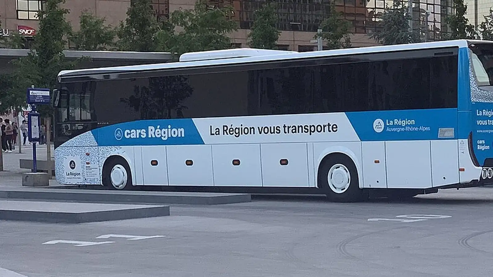 Autocar blanc et bleu sur une place