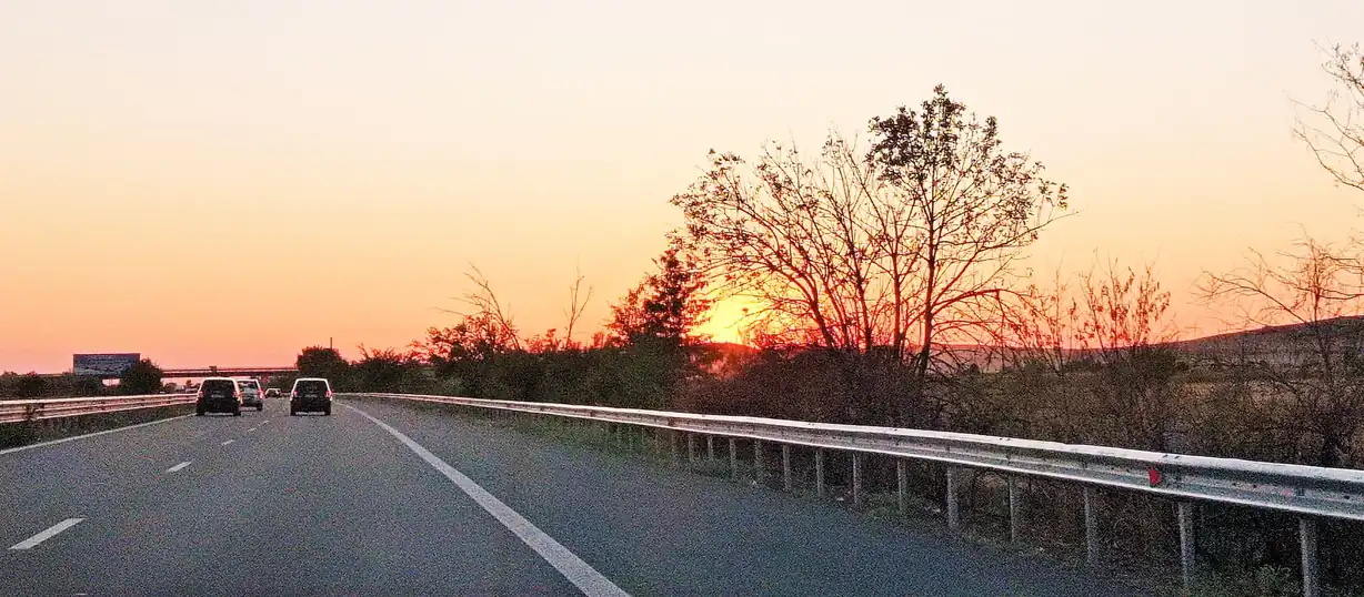 Autoroute au coucher du soleil, voitures au loin