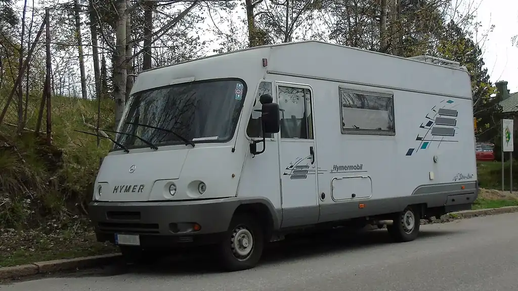 Camping-car blanc garé au bord d’une route